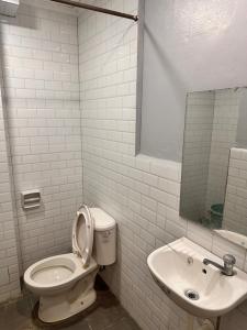 a white bathroom with a toilet and a sink at Capitol Tourist Inn 2026 in Cebu City