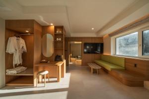 a dressing room with a green couch and a mirror at 신북 온심재 in Sajŏng-dong