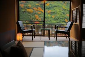 湯河原町にあるふきや旅館の椅子が2脚置かれたバルコニーからは木々が見える。