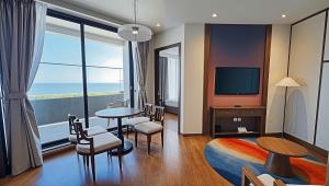 a living room with a table and a television at Mandala Sands Mũi Né in Phan Thiet