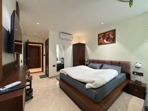a bedroom with a bed and a flat screen tv at Hotel Buransh in Haldwāni