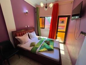 a bedroom with a bed with a table and a window at NGK Hôtel Apartment in Bafoussam