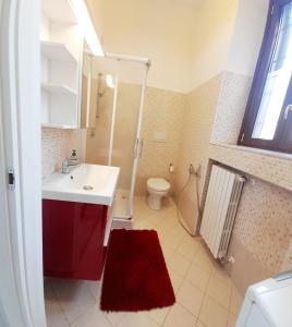 a bathroom with a red sink and a toilet at Appartamento La Corte in Inveruno +5 photos