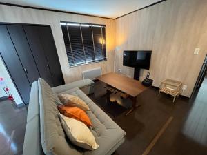 a living room with a couch and a wooden table at Stay923 in Asahikawa