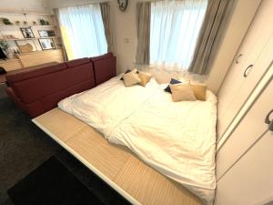 a large bed in a room with a red couch at Stay923 in Asahikawa