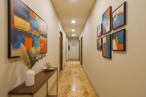 a hallway with many paintings on the walls at FabHotel MB International in Kolkata