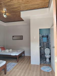a bedroom with a bed and a toilet in a room at EL3 Z'sPLACE HOSTEL in San Vicente