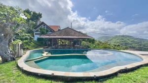 a swimming pool with a gazebo next to a house at Yoga bale house3 in Padangbai