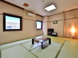 a room with a coffee table and a television at First Inn Haiki in Sasebo