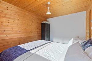 a bedroom with wooden walls and a large bed at Panoramic Alpine Garden Retreat in Vissoie