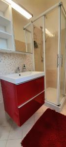 a bathroom with a red sink and a shower at Appartamento La Corte in Inveruno