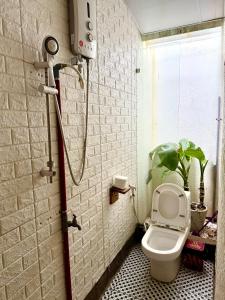 a bathroom with a shower with a toilet and a plant at Homestay Xóm Rớ in Ðông Tác (1)