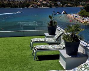 two chairs on a balcony with a view of a beach at Holidays Roko - Sea View Apartments with Pool in Grebaštica