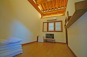 a bedroom with a bed and a tv in a room at Jeonju Hanok Agbae in Jeonju
