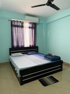 a bedroom with a bed with a ceiling fan at Gray Haven Homestay in Guwahati