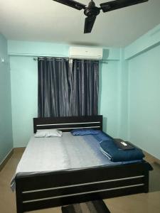a bedroom with a bed with a ceiling fan at Gray Haven Homestay in Guwahati