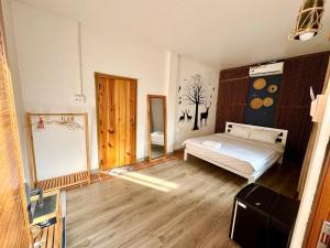 a bedroom with a bed and a wooden floor at Homestay Xóm Rớ in Ðông Tác (1) +7 photos