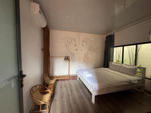a bedroom with a bed and two drawings on the wall at Homestay Xóm Rớ in Ðông Tác (1)