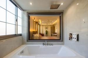 a bath tub in a bathroom with a large mirror at The Delhi Dreams - A Luxury Hotel in New Delhi