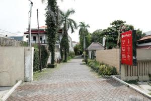 a brick road with a sign next to a building at RedDoorz @ Wiyung 2 in Kedurus