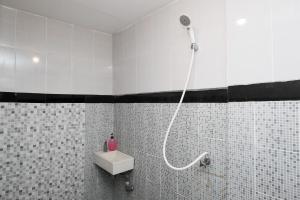 a bathroom with a shower with a sink and a toilet at RedDoorz @ Wiyung 2 in Kedurus