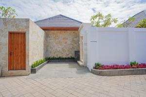 a house with a wooden door and some flowers at Villa Sucasas, Luxury Pool Villa Nusa Dua, Bali in Nusa Dua