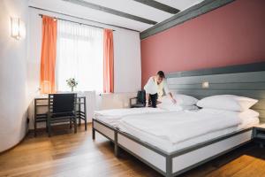 a woman standing on a bed in a hotel room at Hotel Kloster Eberbach in Eltville