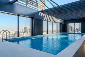 a swimming pool in a building with windows at Stella Stays King Fahd - Furnished Apartments in Riyadh