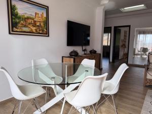 a dining room with a glass table and white chairs at Beldi Chic vue Mer - Taghazout in Agadir nʼ Aït Sa