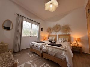 a bedroom with two beds and a large window at Beldi Chic vue Mer - Taghazout in Agadir nʼ Aït Sa +41 photos