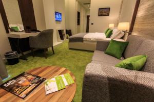 a hotel room with a bed and a couch and a table at Kalamper Hotel & Spa in Dobra Voda