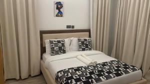 a bedroom with a bed with a black and white comforter at The Beleza Suites in Kericho