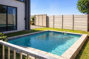 a swimming pool in the yard of a house at Van Temp Beach House in Britannia Bay