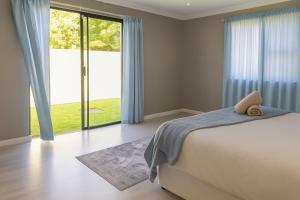 a bedroom with a bed and a large window at Van Temp Beach House in Britannia Bay +41 photos