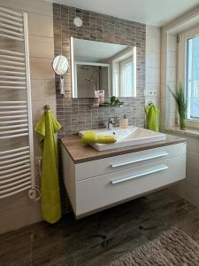 a bathroom with a sink and a mirror at Gästehaus Schneider in Eppishausen +26 photos