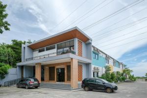 two cars parked in front of a building at Sans Salmas Mojokerto in Kranggan