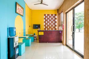 a lobby with yellow and blue walls and a door at Sans Salmas Mojokerto in Kranggan