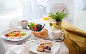 a table with two plates of breakfast foods and drinks at Hotel Park in Čakovec