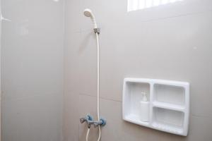 a shower with a soap dispenser in a bathroom at Sans Salmas Mojokerto in Kranggan +30 photos
