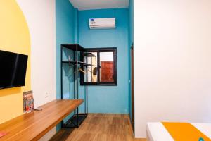 a room with a bed and a blue wall at Sans Salmas Mojokerto in Kranggan