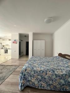 a bedroom with a bed with a blue floral bedspread at Апартаменти студія in Truskavets