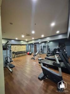a gym with treadmills and machines in a room at Solace - 1BR Brenthill Condo with Balcony Near Session and SM in Baguio