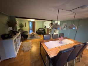 a living room with a wooden table and chairs at Blomstergården in Vilshult