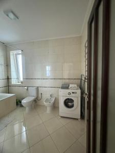 a bathroom with a toilet sink and a washing machine at Апартаменти студія in Truskavets +32 photos