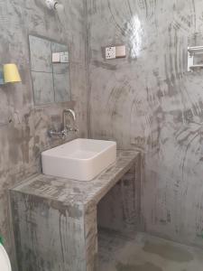 a bathroom with a white sink on a marble counter at Siril Guesthouse Hostel in Nuwara Eliya