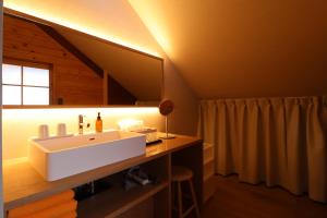 a bathroom with a sink and a mirror at Kurasako Onsen Sakura in Minamioguni