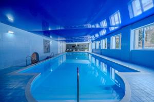 a large swimming pool with a blue ceiling at Dobrzyński Resort Topaz in Świeradów-Zdrój