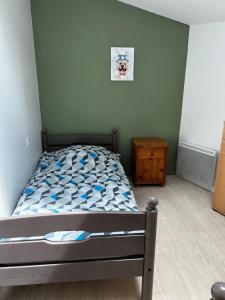 a small bedroom with a bed and a night stand at Gite Camélia in La Réorthe