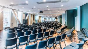 an empty room with blue chairs in a building at Scandic Continental in Stockholm