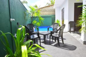 a patio with chairs and a table and a pool at Ceylon Relax Villa in Aluthgama